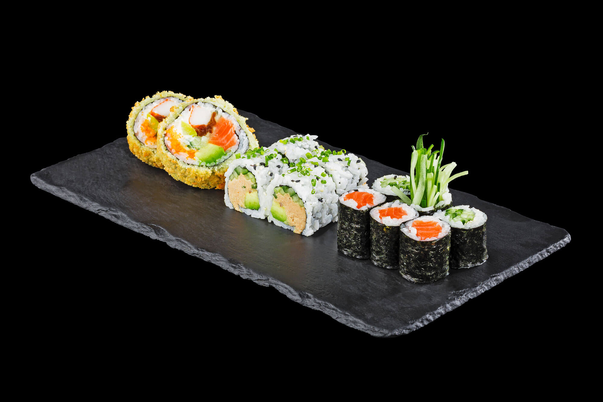 Sushi Platte und Sake Maki auf Schieferplatte vor schwarzem Hintergrund