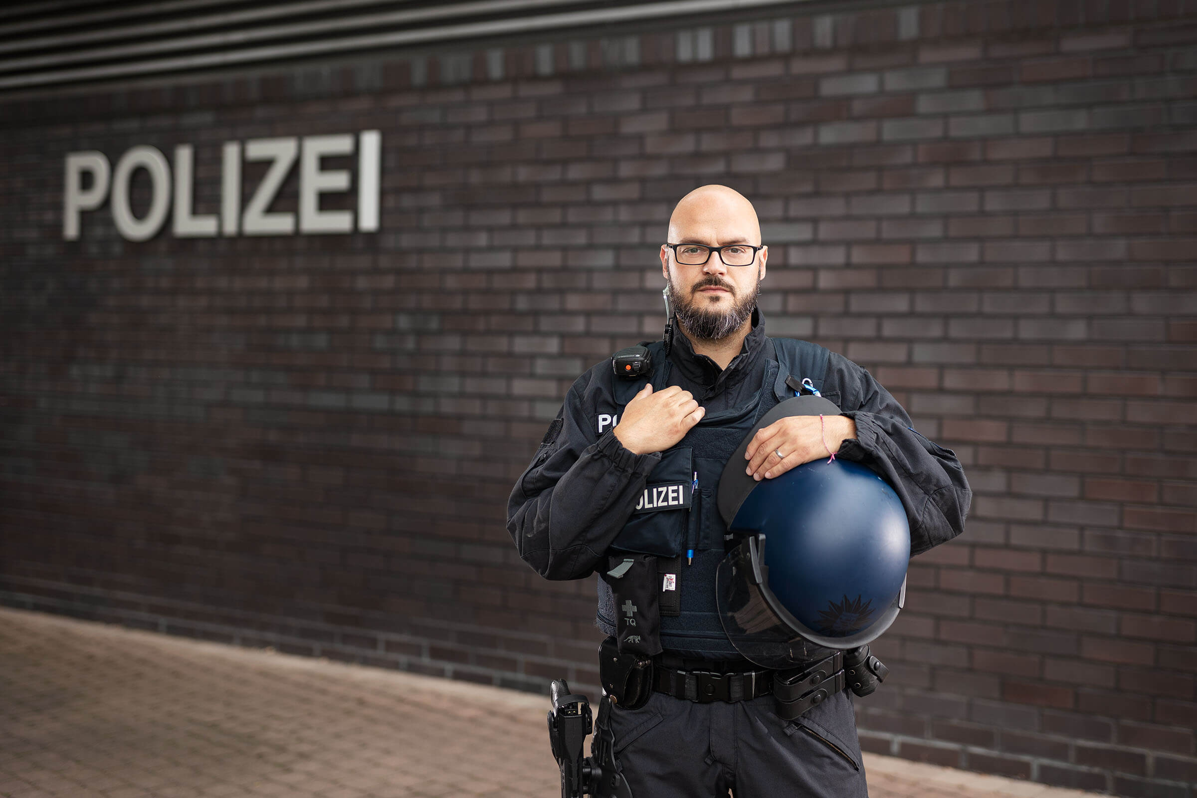 Polizist in Ausrüstung vor der Dienststelle
