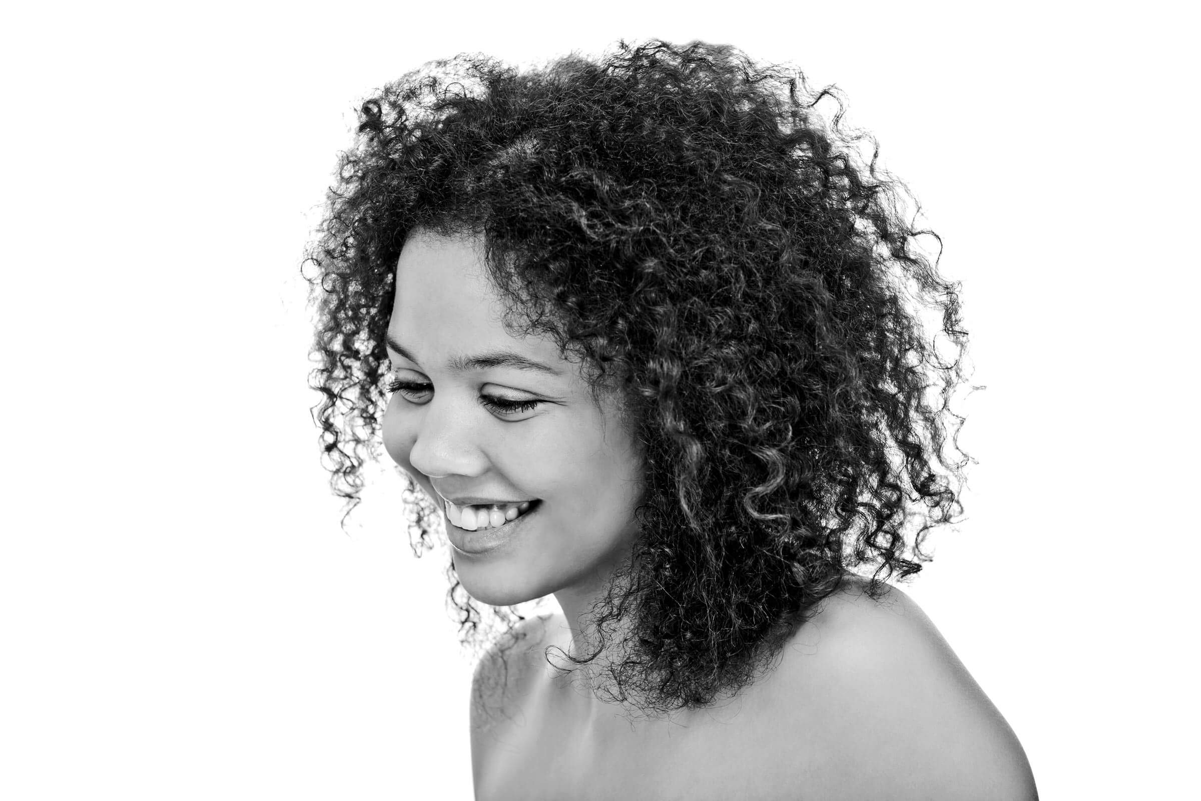 Studioaufnahme einer jungen lächelnden Frau vor weißem Hintergrund