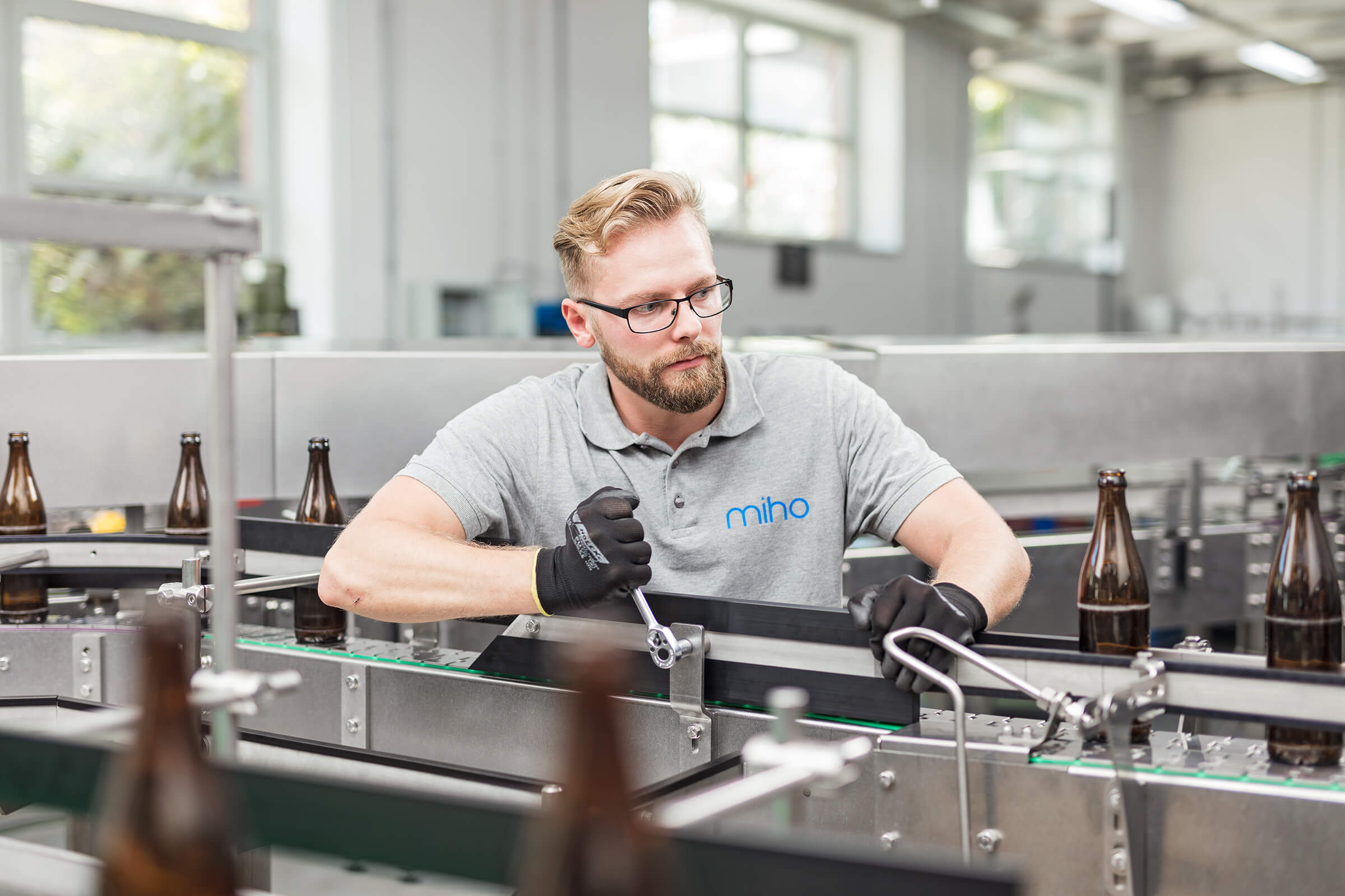 Mitarbeiter justiert eine Maschine in einer Industriehalle