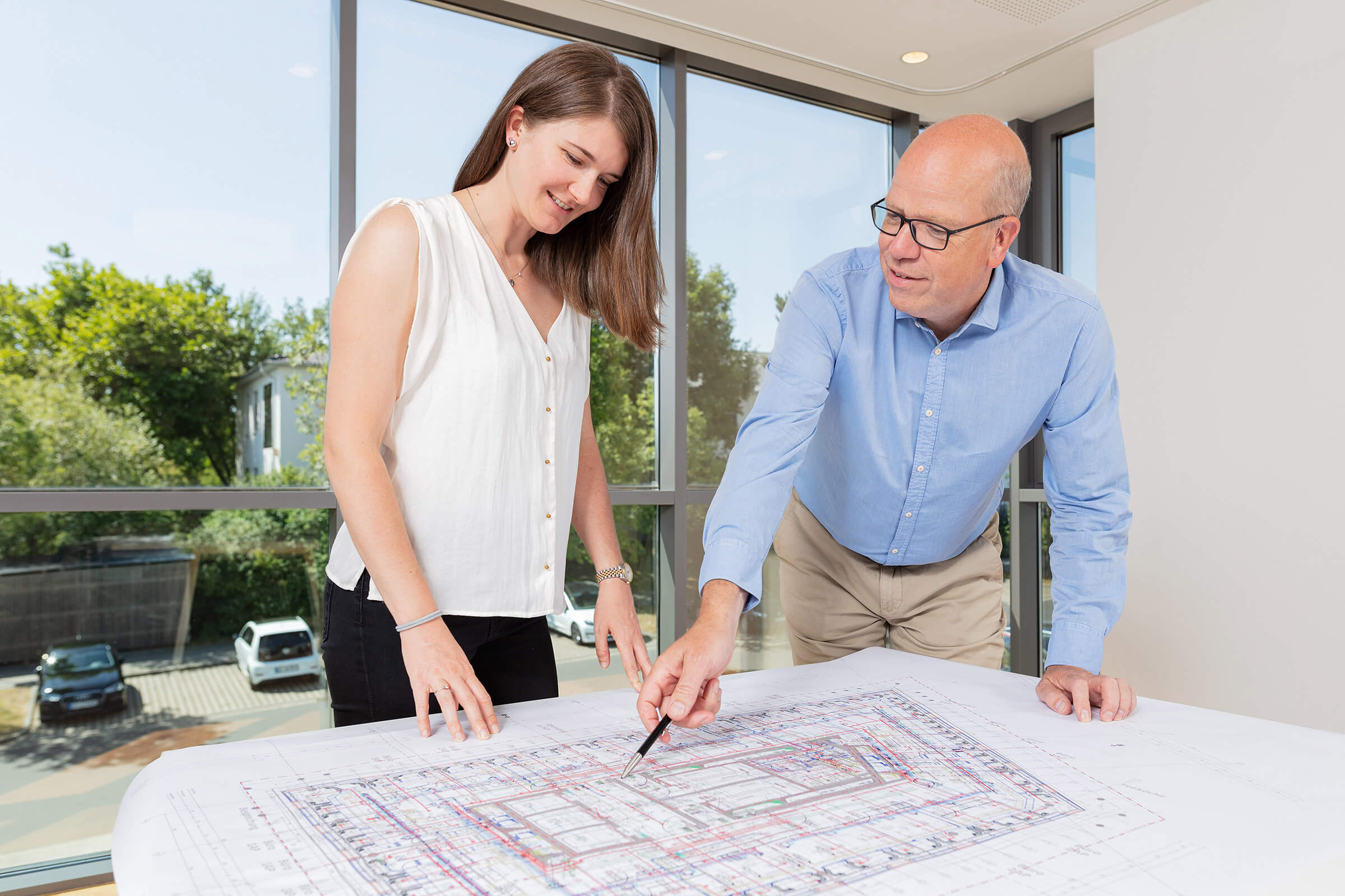 Interaktion zweier Ingenieure mit einem Bauplan