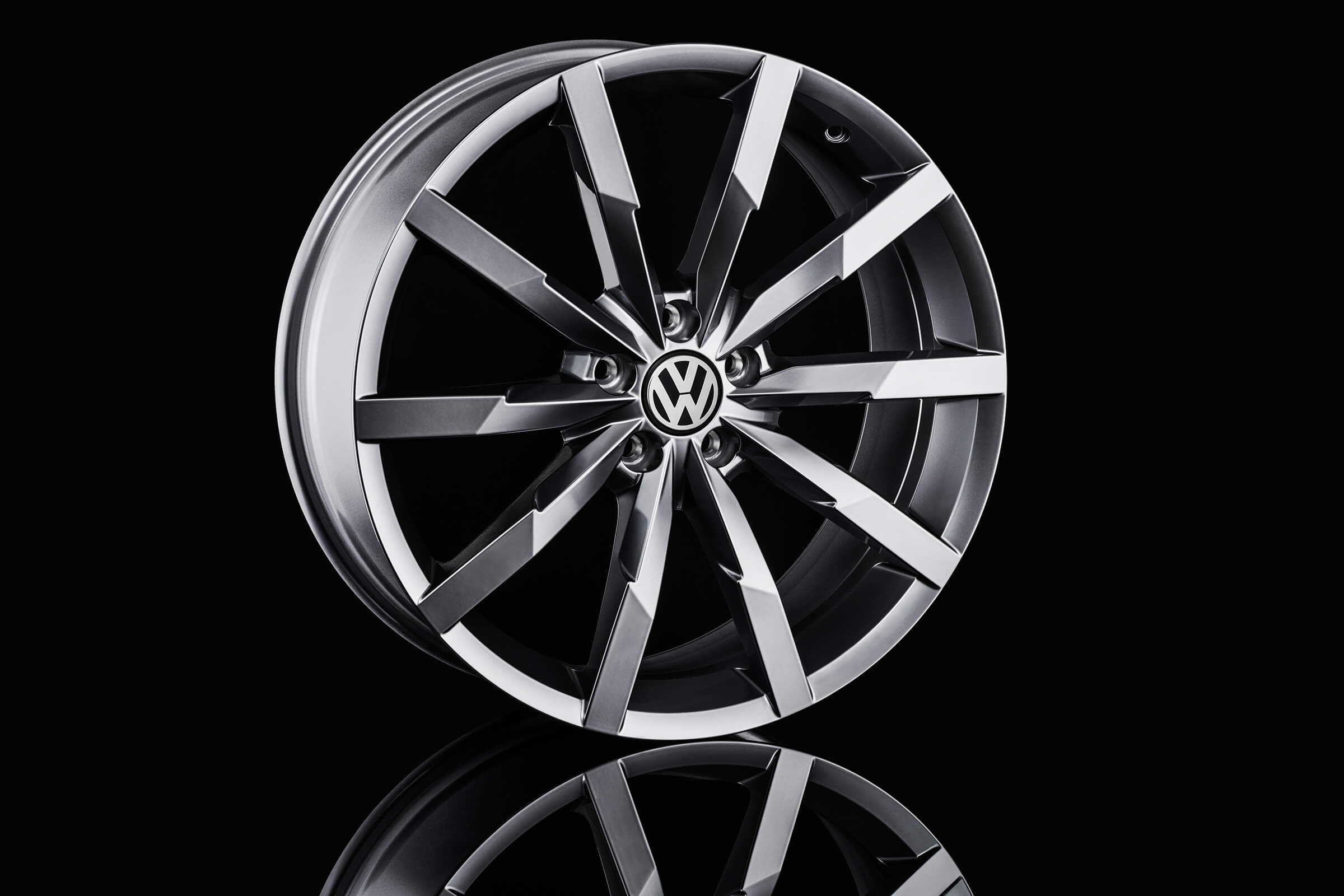 Volkswagen Felge mit Spiegelung vor schwarzem Hintergrund