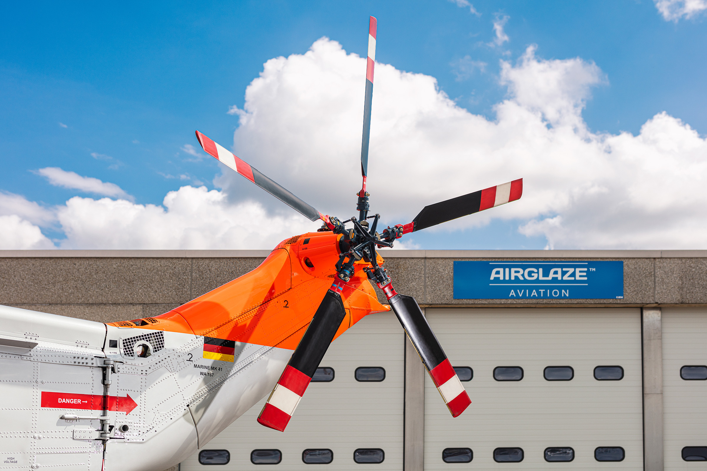 Rotor von Hubschrauber vor Hangar und blauem Himmel