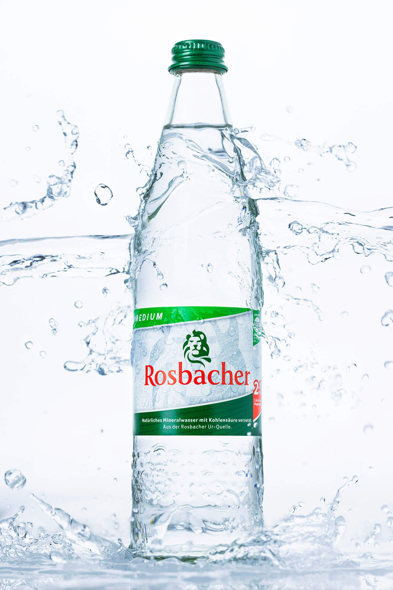 Wasserflasche mit Wasserspritzern vor hellem Hintergrund