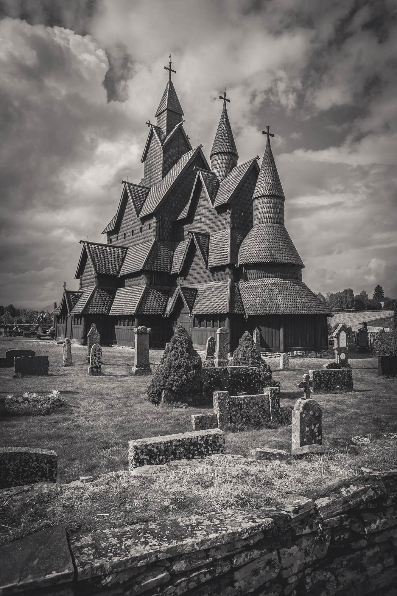 Stabkirche auf Friedhofsgelände mit dramatischem Himmel