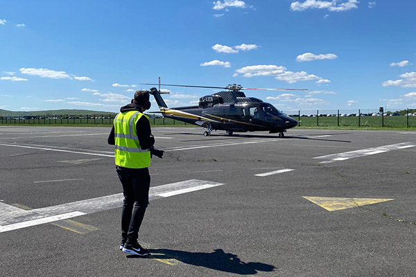 Fotograf Alex Schmitt vor einem Hubschrauber am Flughafen