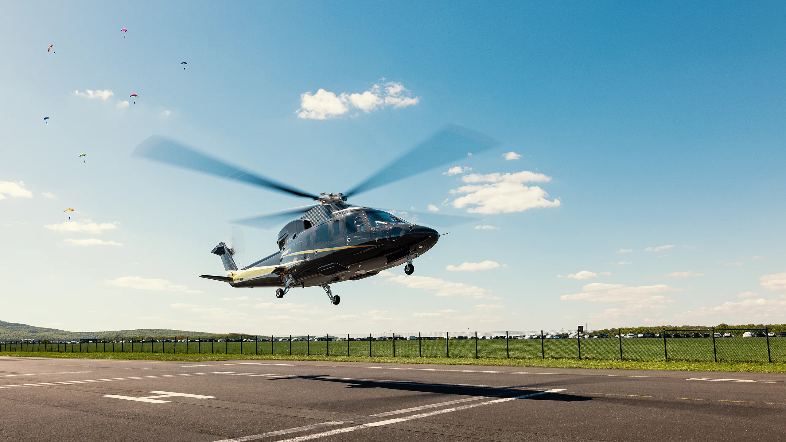 Helikopter beim Abheben von einer Start- und Landefläche unter blauem Himmel.